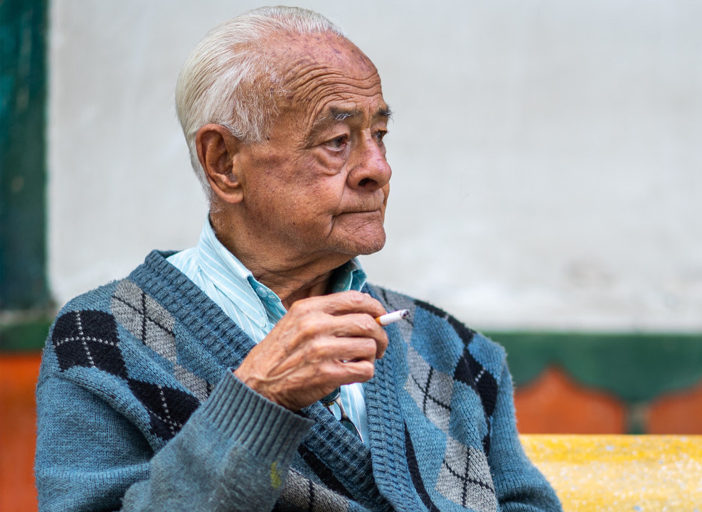 На фото: пожилой мужчина держит в руке сигарету. @robinnoguier | unsplash.com