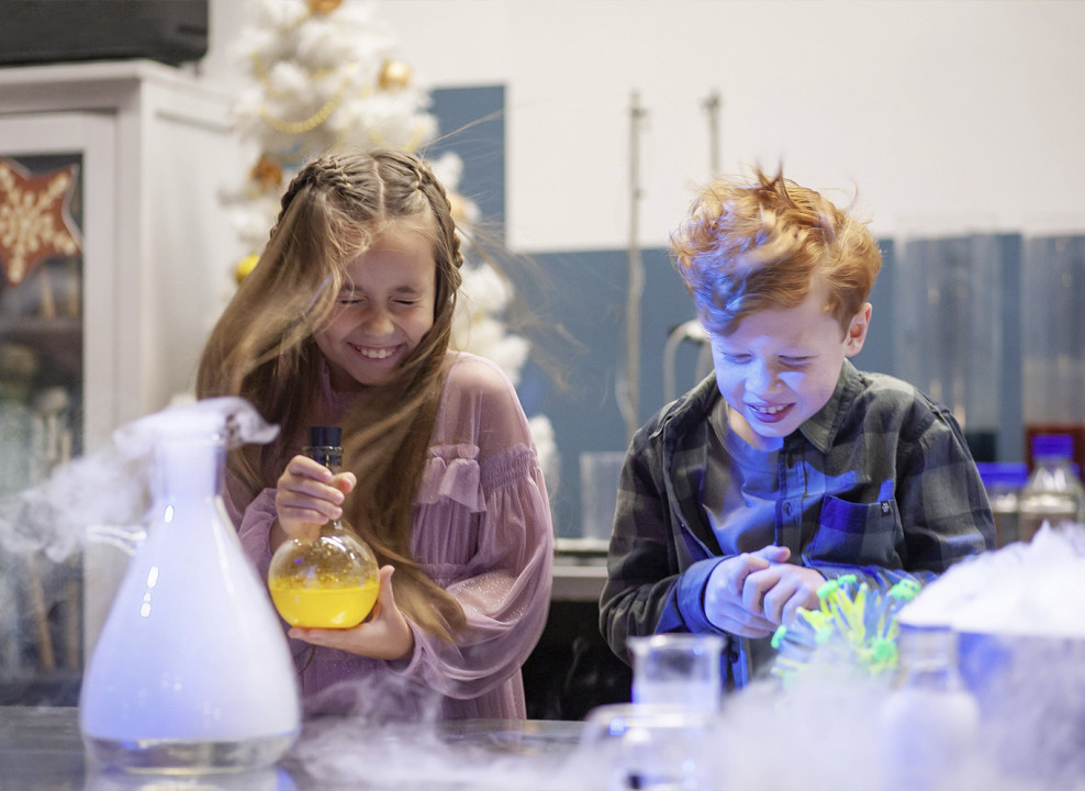 Двое детей делают химический эксперимент и жмурятся. Фото: kidburg.ru