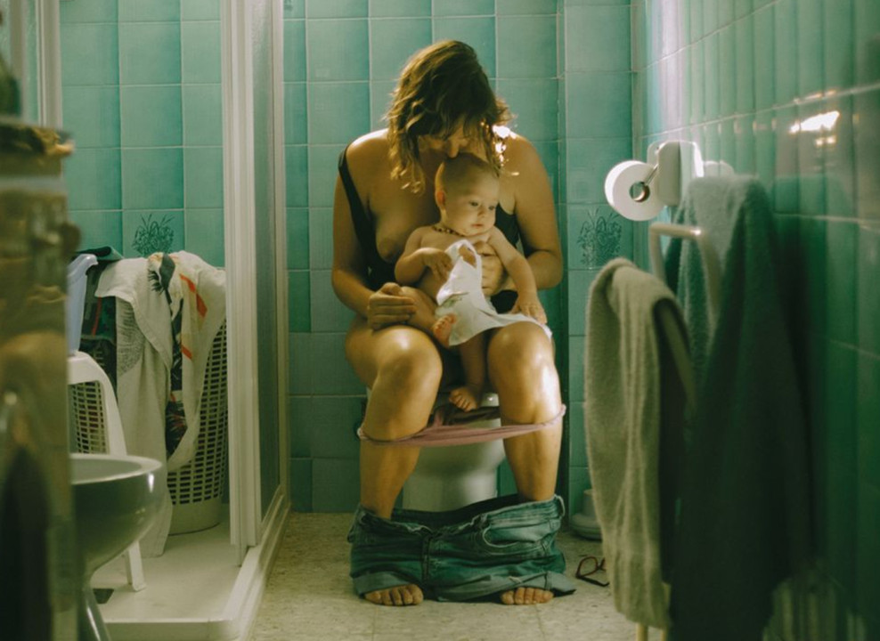 На фото: женщина сидит на унитазе, держит в руках младенца. Iris Muñoz Gomez | teNeues Verlag